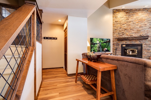 Settle into your cozy living space where warm wood tones meet a stunning stone fireplace. Unwind on the plush sofa, catch your favorite show, and feel right at home.