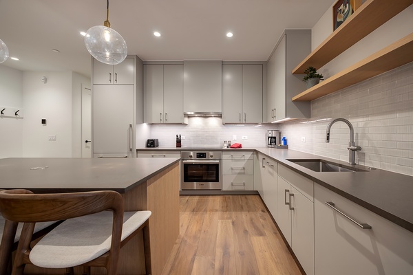 Your fully equipped kitchen invites you to prepare meals with ease, featuring sleek countertops, modern appliances, and warm wood accents that create a welcoming space for cooking and gathering.