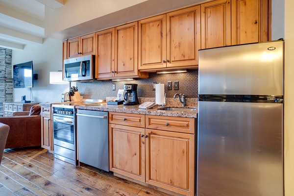 Your fully equipped kitchen features stainless steel appliances, granite counters, and warm wood cabinetry—perfect for morning coffee or preparing home-cooked meals during your stay.