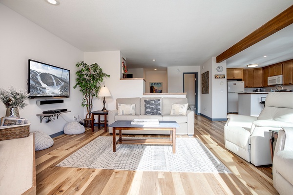 Unwind in your bright, open living space with comfortable seating, a cozy area rug, and a well-appointed kitchen just steps away—perfect for relaxing after a day of adventure.