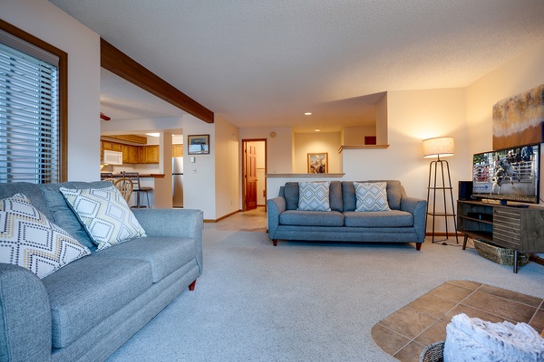 Step into your spacious living room with comfortable seating and an open layout that flows into the kitchen—perfect for relaxing after a day of adventure.