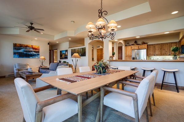 Gather around this inviting dining table where your group can share meals and memories. The open layout flows seamlessly into a cozy living space and fully-equipped kitchen, making your stay feel like home.