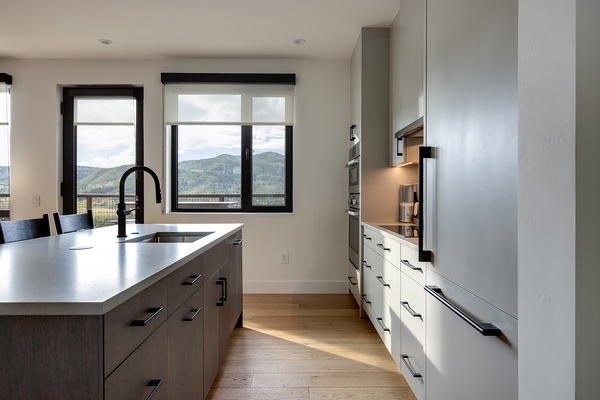 Prepare your favorite meals in this sleek, modern kitchen, where mountain views frame every moment and natural light fills the space.
