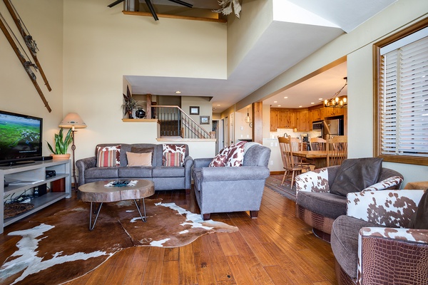 Unwind in your spacious living area with high vaulted ceilings, plush seating, and warm wood floors. The open layout flows seamlessly into a fully-equipped kitchen, perfect for gathering after mountain adventures.