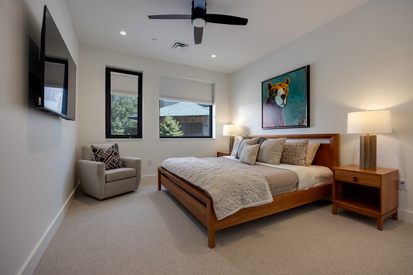 Slip into your serene bedroom, where a plush bed and soft lighting invite you to unwind. Natural light streams through modern windows, while a ceiling fan keeps your space perfectly comfortable.
