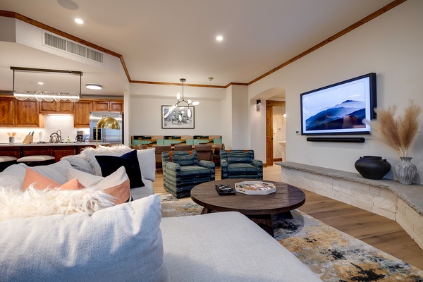 Sink into plush seating and unwind in your open-concept living space, where modern comfort meets mountain elegance with a cozy fireplace and entertainment center.
