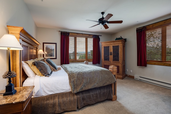 Slip into your peaceful retreat with a plush bed, warm wood furnishings, and soft natural light filtering through the windows. Your cozy escape awaits.