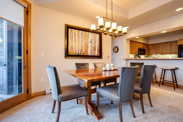 Gather around this inviting dining table where you'll share meals and memories with loved ones. The warm wood tones and soft lighting create the perfect atmosphere for your mountain retreat.