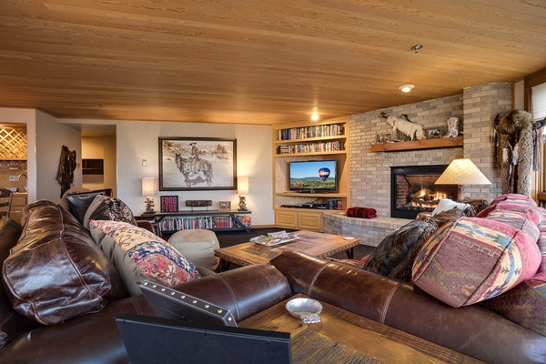 Sink into plush leather couches by your crackling fireplace, perfect for cozy evenings with loved ones. Western charm meets comfort in this inviting living space designed for relaxation.