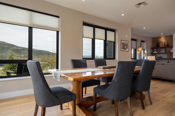 Gather around this warm wood dining table and share meals while taking in stunning mountain views. Thoughtful design blends modern comfort with natural beauty—your perfect mountain retreat awaits.