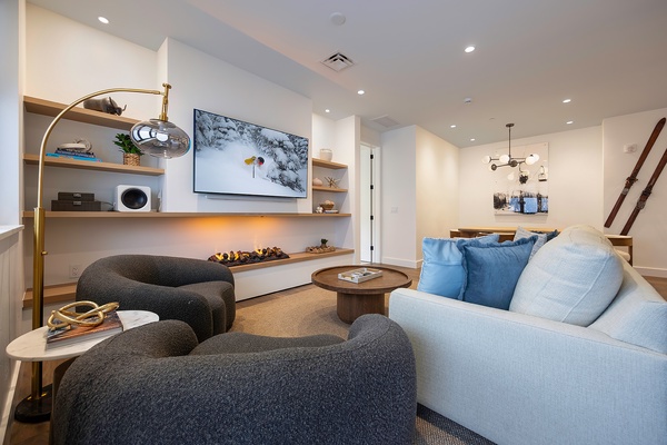 Settle into your stylish living space, where modern design meets coastal calm. Curved seating and warm lighting invite you to unwind after a day exploring, while natural textures create a soothing retreat.