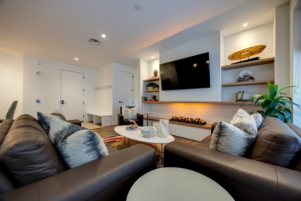 Sink into plush seating and unwind by the sleek fireplace. This modern living space welcomes you with coastal-inspired décor, warm ambient lighting, and all the comforts you need to relax after a day of exploring.