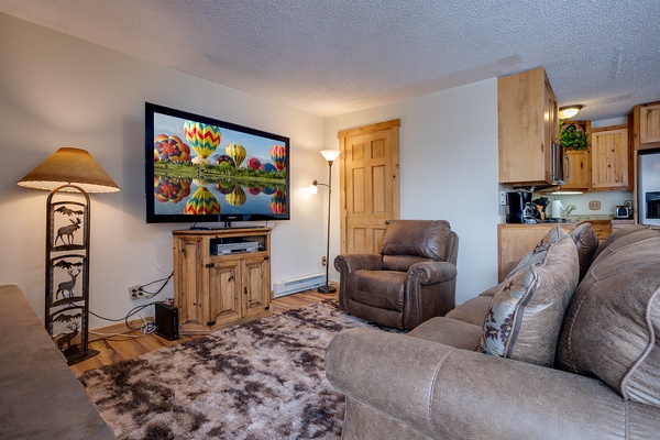 Unwind in your cozy living space, complete with a large flatscreen TV, plush leather seating, and rustic mountain charm that makes you feel right at home.