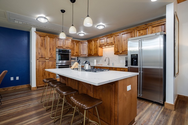 Picture yourself preparing your favorite meal in this bright, spacious kitchen with gleaming stainless appliances, warm wood cabinetry, and a large island perfect for gathering around morning coffee.
