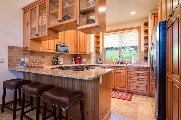You'll love cooking in this warm, beautifully appointed kitchen featuring rustic pine cabinetry, granite countertops, stainless appliances, and plenty of natural light pouring in.