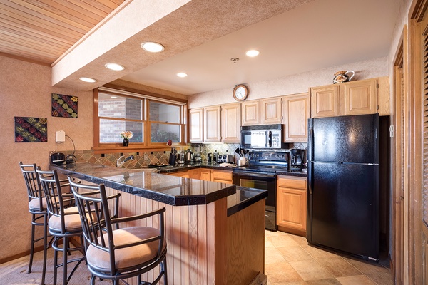 Your fully equipped kitchen awaits with granite countertops, modern appliances, and a convenient breakfast bar where you can sip morning coffee while planning the day's adventures.