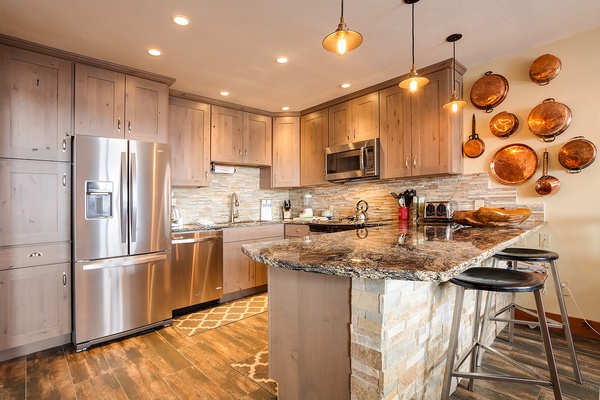 A fully equipped kitchen with granite countertops, stainless steel appliances, and rustic charm awaits you. Gather around the island for morning coffee or meal prep in your mountain home away from home.