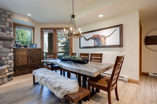 Gather around this stunning live-edge table where rustic elegance meets mountain charm—your group dinners will feel like special occasions under the warm chandelier glow.