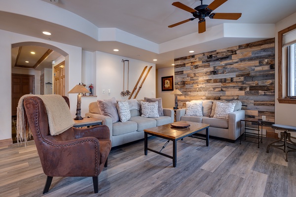 Relax in your inviting living room with vaulted ceilings, rustic wood accent wall, and comfortable seating—perfect for unwinding after exploring the area.
