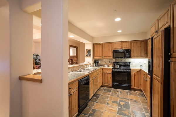 Your fully equipped kitchen features warm wood cabinetry, granite counters, and modern appliances—everything you need to prepare delicious meals during your stay.