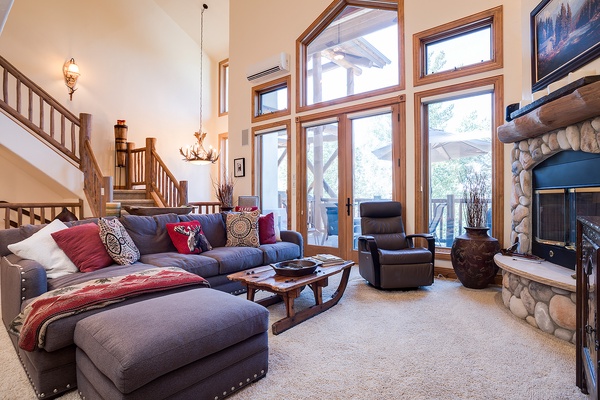 Step into your spacious alpine retreat where vaulted ceilings and floor-to-ceiling windows frame stunning mountain views. Sink into plush seating by the stone fireplace after a day of adventure.