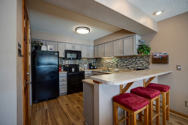 Your fully equipped kitchen features modern appliances, elegant backsplash, and a breakfast bar where you can savor morning coffee with family or prep meals together.