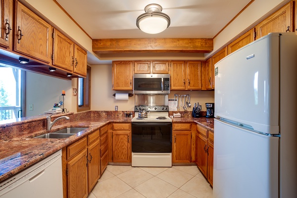 Your fully equipped kitchen features warm oak cabinetry, granite countertops, and modern appliances—perfect for whipping up home-cooked meals during your stay.