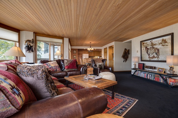Sink into rich leather sofas under warm wood-paneled ceilings, where rustic artwork and cozy textiles create your perfect mountain retreat for relaxation and togetherness.