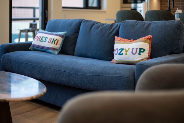 Sink into this plush sofa and unwind—colorful cushions and natural light make your downtime feel extra cozy.