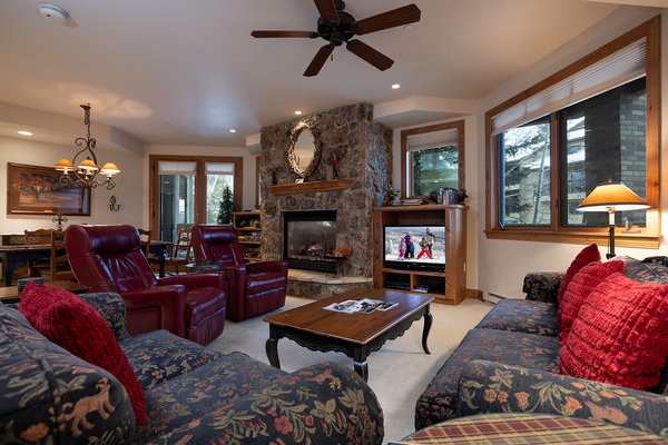 Sink into plush seating by the stone fireplace, where you can unwind after your mountain adventures with your favorite shows and cozy warmth.