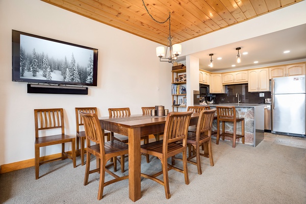 Gather around the handcrafted wooden table for meals and laughter, with a warm vaulted ceiling overhead and a fully equipped kitchen just steps away for easy entertaining.