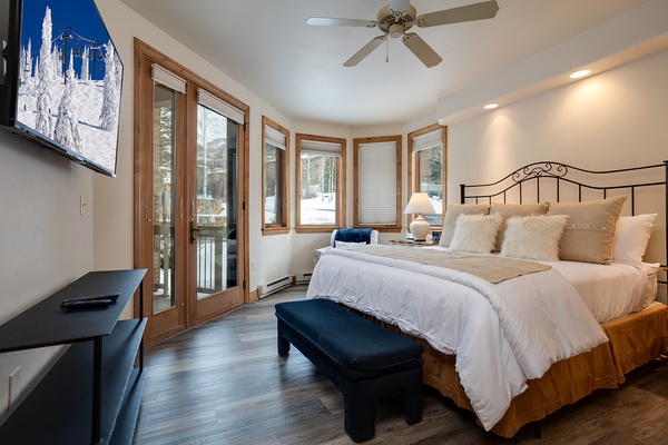 Wake up to stunning winter views through floor-to-ceiling windows. Your cozy bedroom features plush bedding, a private balcony, and peaceful mountain scenery just outside.