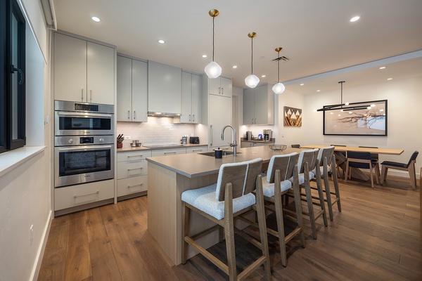 Gather with your group in this beautiful open kitchen and dining space, where sleek countertops and modern appliances make meal prep a breeze while everyone stays connected.