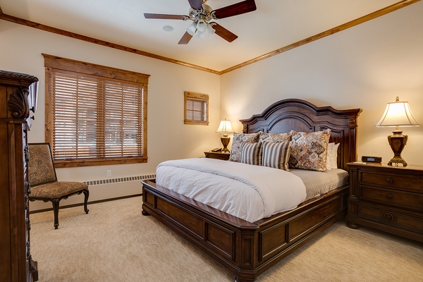 Sink into crisp linens and plush pillows in your elegant bedroom, where warm wood tones and soft lighting create a peaceful retreat for restful nights.