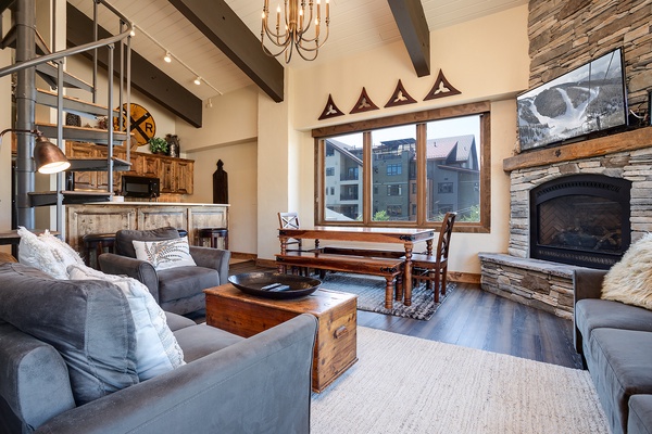 Gather around the roaring fireplace in your cozy living room, where rustic elegance meets mountain charm. Vaulted ceilings, exposed beams, and plush seating create the perfect retreat after a day exploring the slopes.