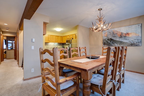 Gather around this inviting rustic table where your group can share meals and stories under the warm glow of a striking antler chandelier, with mountain views setting the perfect alpine backdrop.
