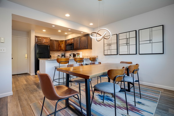 Gather around the spacious dining table where your group can share meals and laughter together, with a fully equipped kitchen just steps away for all your culinary adventures.