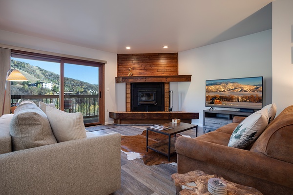 Relax by the fireplace and mountain views in your cozy living room. Plush seating, warm wood accents, and a modern TV await.