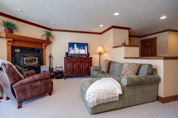 Unwind in your cozy living room with a fireplace, comfortable seating, and entertainment center—perfect for relaxing evenings after your adventures.