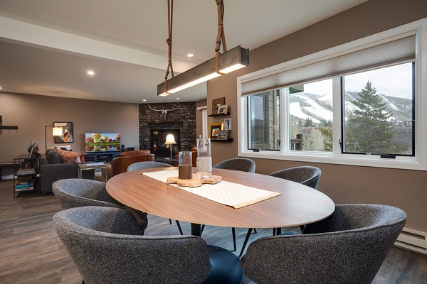 Gather around this stylish oval table with mountain views right outside your window. The open living space flows effortlessly, perfect for memorable meals and cozy evenings by the fire.