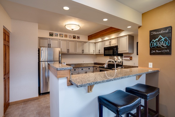 Gather around this spacious kitchen with granite countertops, full appliances, and bar seating—perfect for preparing meals together and sharing stories after a day on the slopes.