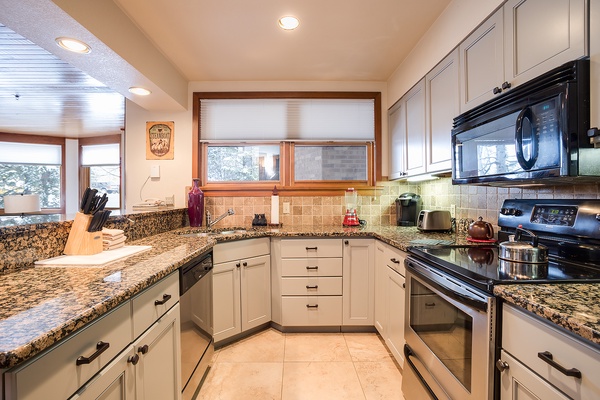 Your well-appointed kitchen awaits, featuring gleaming granite countertops, stainless appliances, and abundant storage. Natural light pours in as you prepare meals in this spacious, comfortable cooking space.
