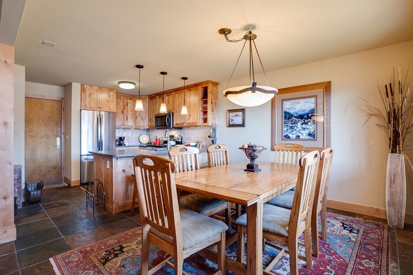 Gather around this handsome dining table with mountain views and a fully equipped kitchen at your fingertips. The warm wood tones and open layout make mealtime feel like home.
