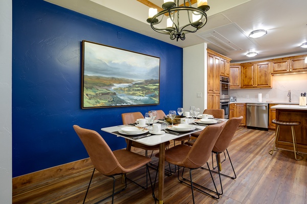 Picture yourself enjoying meals around this inviting dining table, with a fully equipped kitchen at your fingertips. The rich wood tones and bold blue accent wall create a warm, stylish retreat for your mountain getaway.