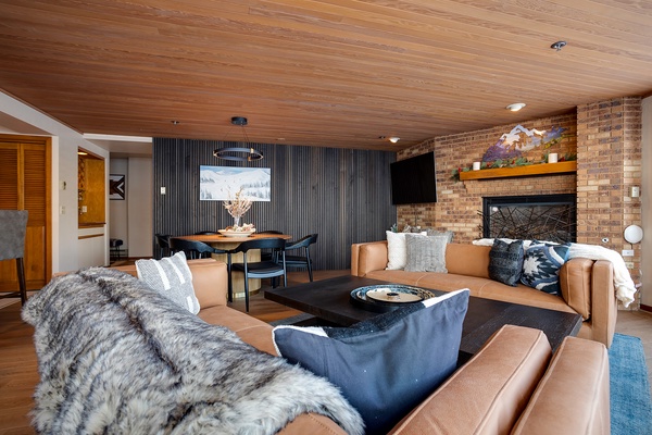 Unwind in this inviting living space where rich leather seating, a cozy fireplace, and warm wood accents create the perfect mountain retreat for your après-ski relaxation.
