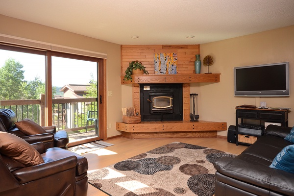 Unwind in your spacious living room, where sunlight streams through the balcony doors and a cozy fireplace invites you to relax after a day of adventure.