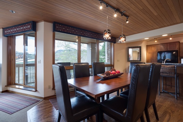 Gather around this elegant dining table with waterfront views streaming through floor-to-ceiling windows, where your meals are framed by serene lake scenery and natural light.