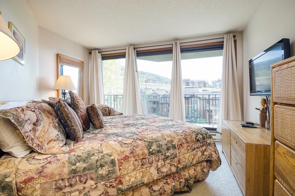 Wake up to stunning mountain views from your cozy bedroom. The large windows frame the slopes, while soft lighting and comfortable furnishings create a peaceful retreat after a day of adventure.