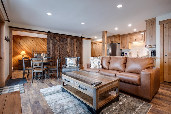 Unwind in your open-concept space with rustic sliding barn door, cozy leather seating, and warm wood details that bring mountain charm home.