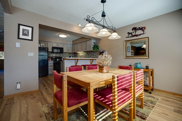 Gather around this inviting dining table where sunlight streams across rich wood and plush seating. With a fully equipped kitchen steps away, your meals together will feel warm and memorable.